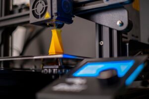 3D-skrivare tillverkar en gul reservdelsliknande komponent