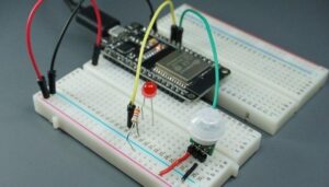 ESP32-mikrokontroller med LED och rörelsesensor på kopplingsdäck